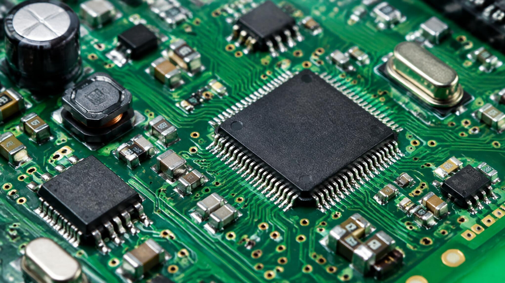 Macro photo of a green circuit board with electronic components